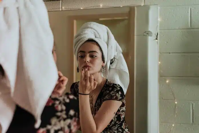 Une femme se faisant une beauté dans la salle de bain